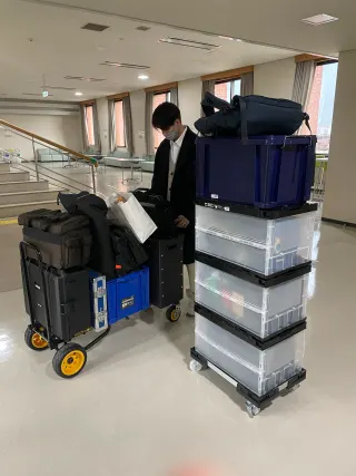 台車に積んだ撮影機材ケースとスタッフ