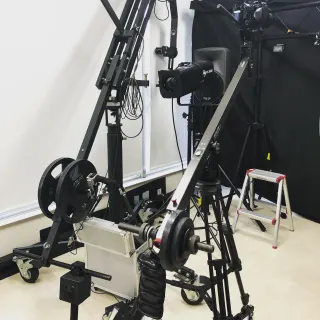 カメラクレーンと撮影用照明を設営した室内の機材風景